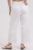 White pants worn by a person on a white background