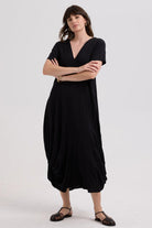 Woman wearing a black dress with crossed arms on a white background