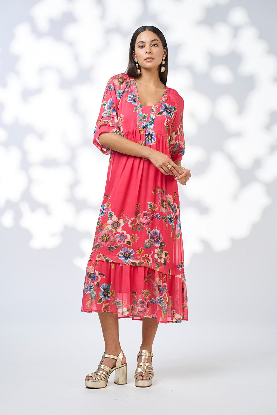 model wearing a pink floral dress against a white background