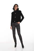 Woman wearing a black sweater and leopard print jeans on a white background
