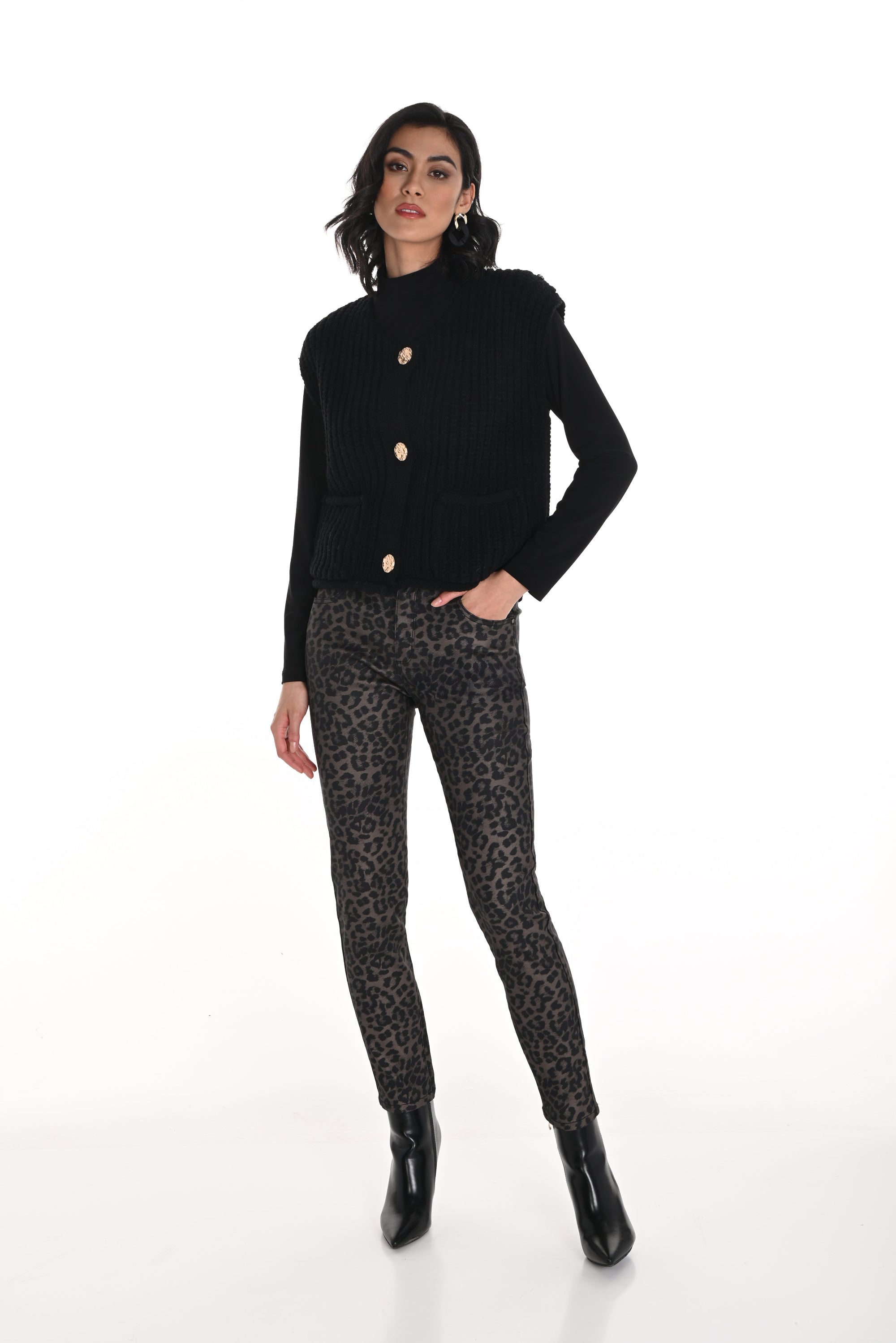 Woman wearing a black sweater and leopard print jeans on a white background