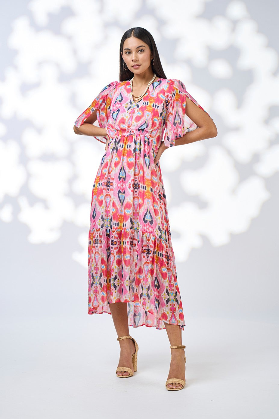 Woman wearing a colorful dress with a pattern against a white background