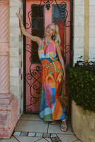 model wearing multi colour maxi dress in front of pink door