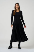 Woman wearing a black pleated dress on a white background