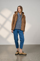 women wearing blue jeans and a brown jacket 