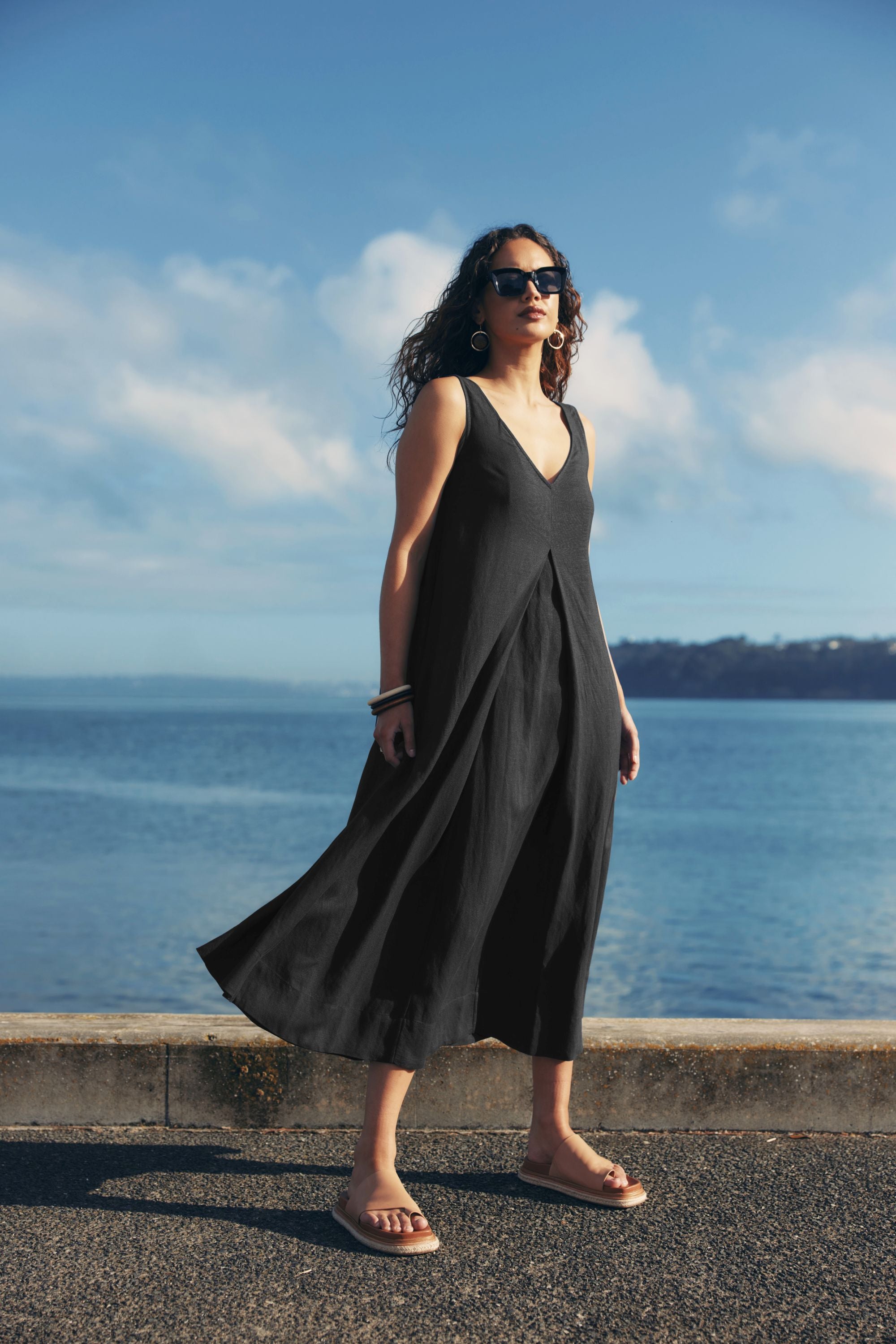 pleat maxi dress black worn by model ocean background