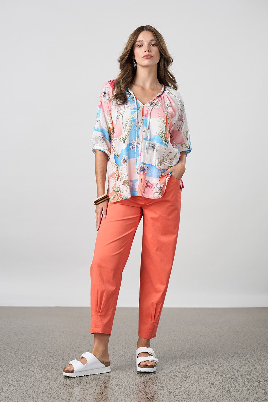 light floral blouse with orange pant worn by model 