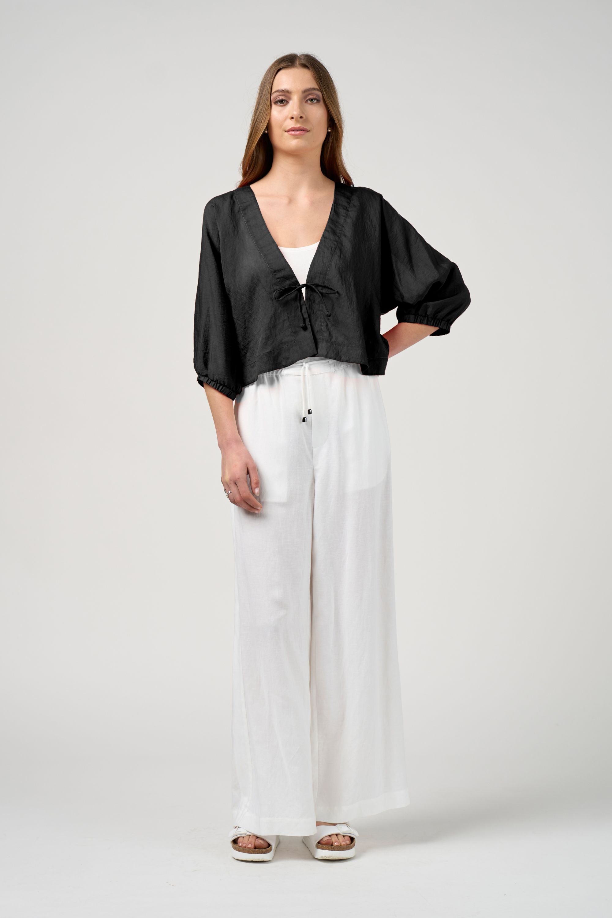 black tie jacket with white pant worn by model 