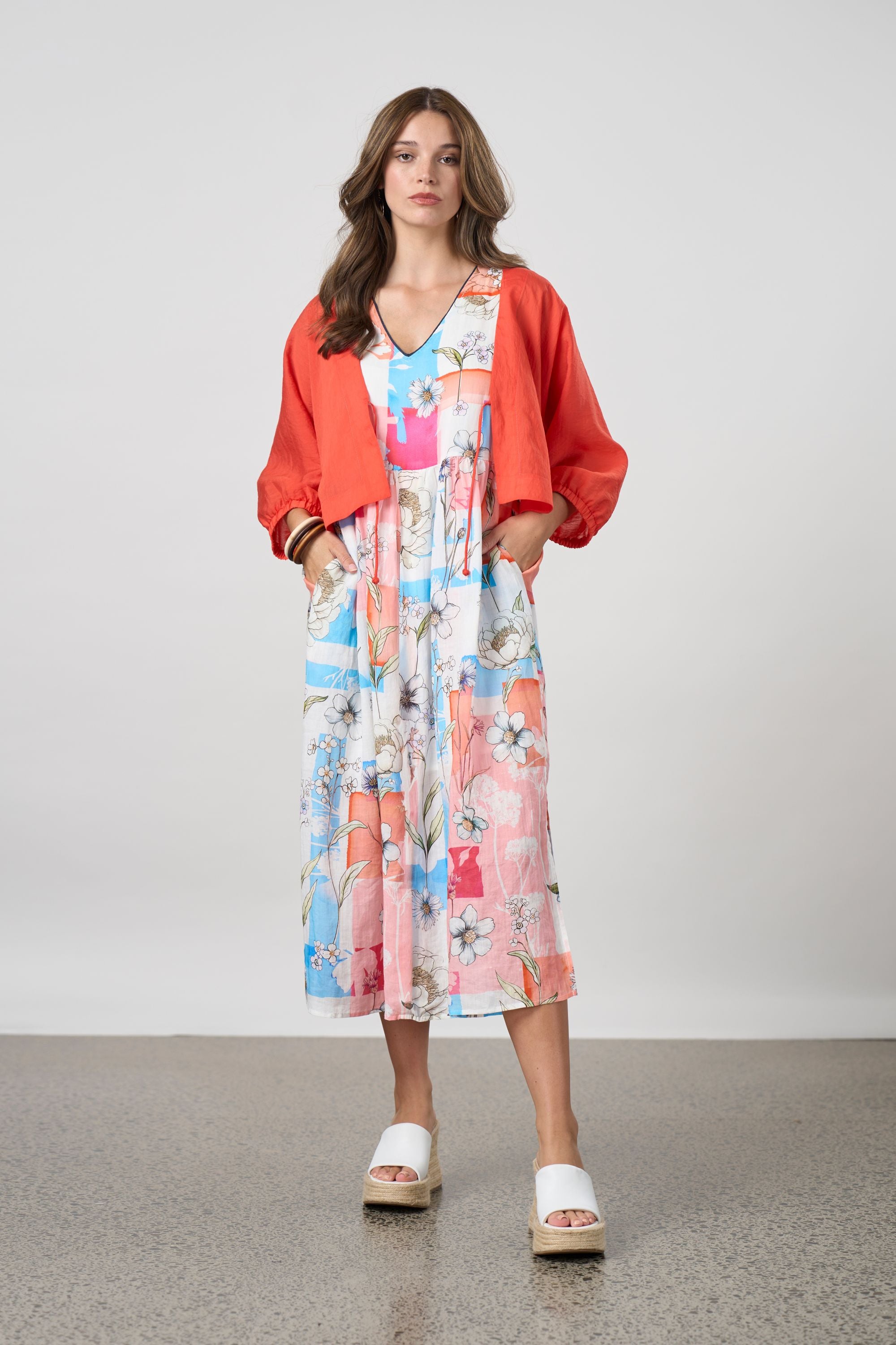 pink multi patchwork long sleeveless dress and orange jacket worn by model 