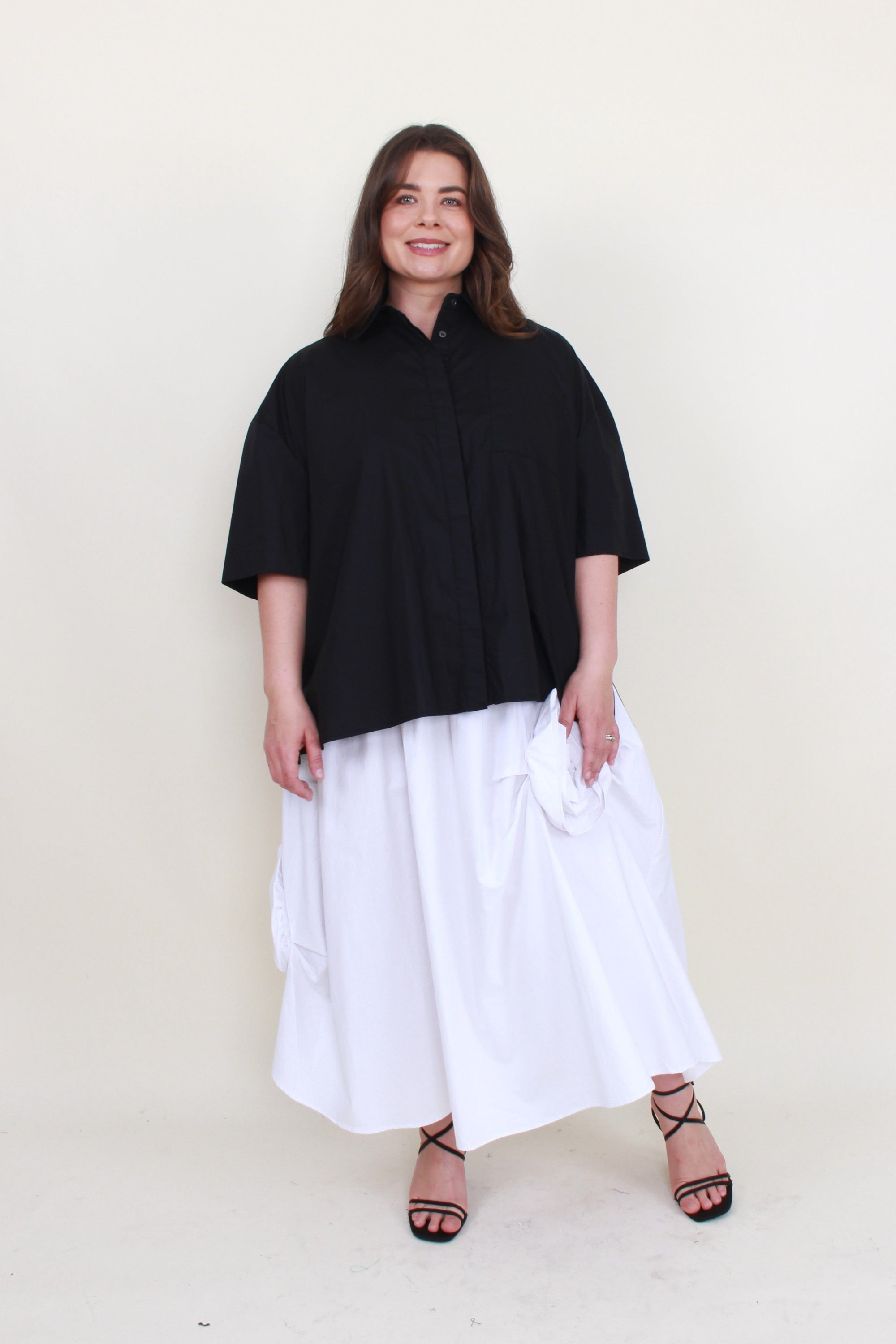 white maxi skirt with rosette appliques and black shirt worn by model