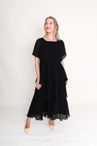 Woman wearing a black dress against a white background