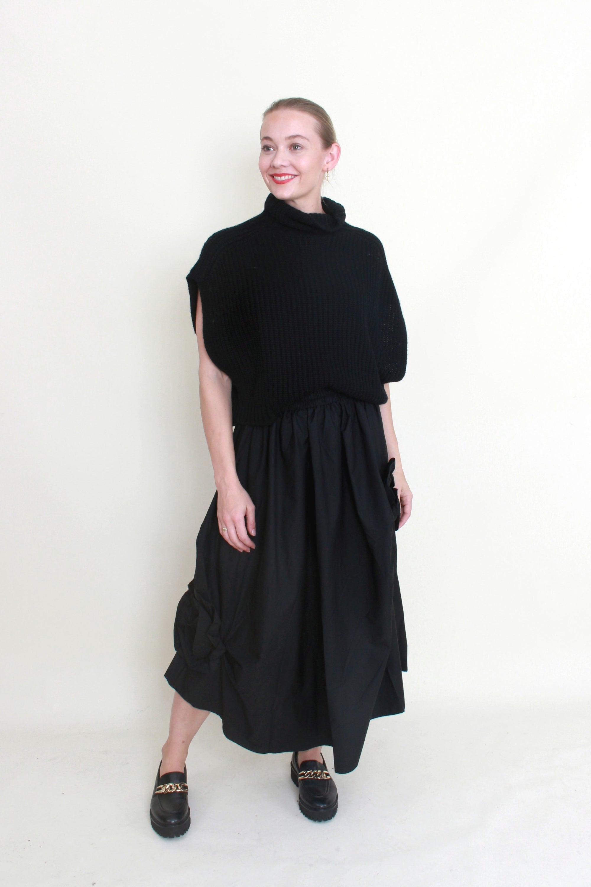 black maxi skirt rosette detail with black knit top worn by model 