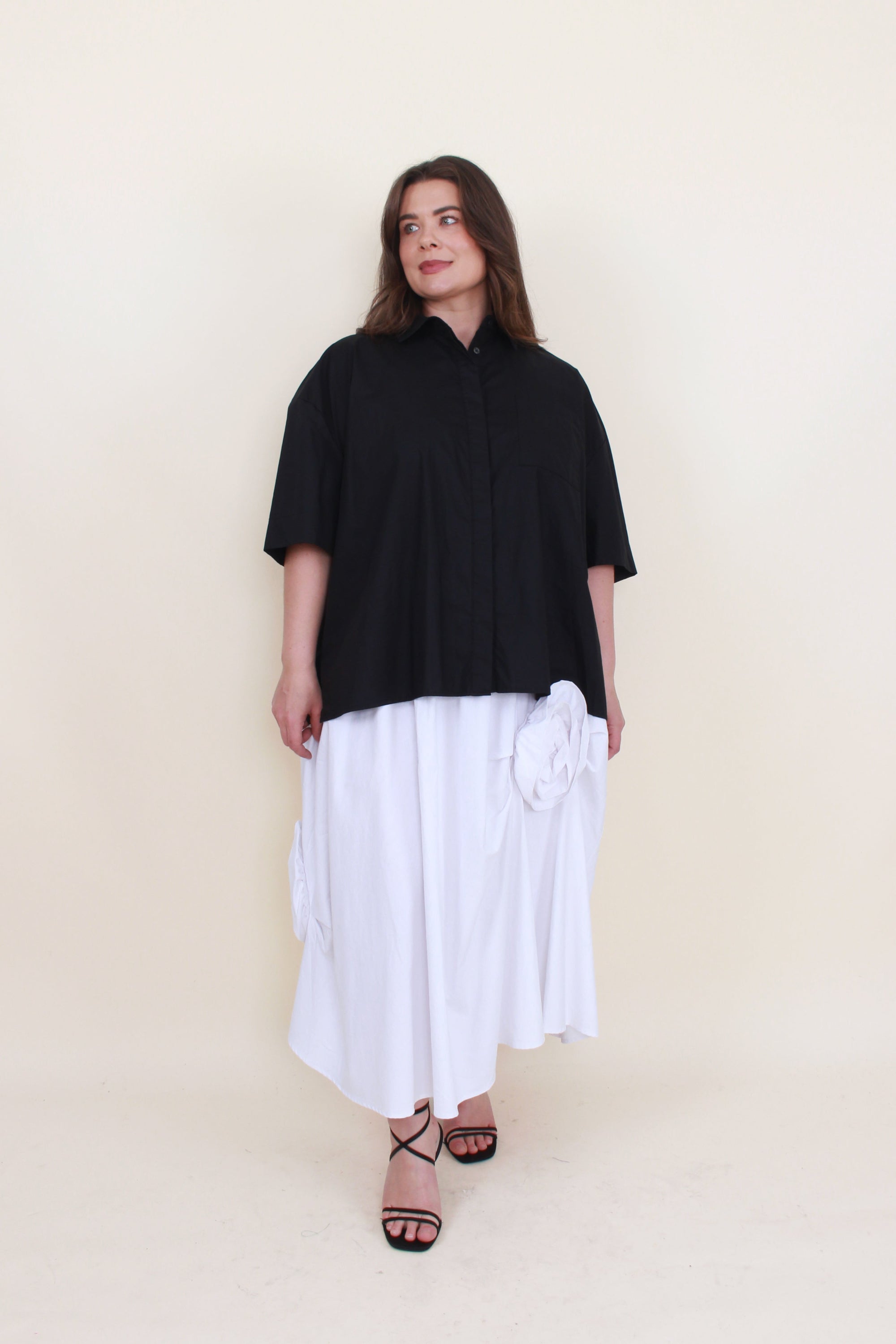 white maxi skirt with rosette appliques and black shirt worn by model