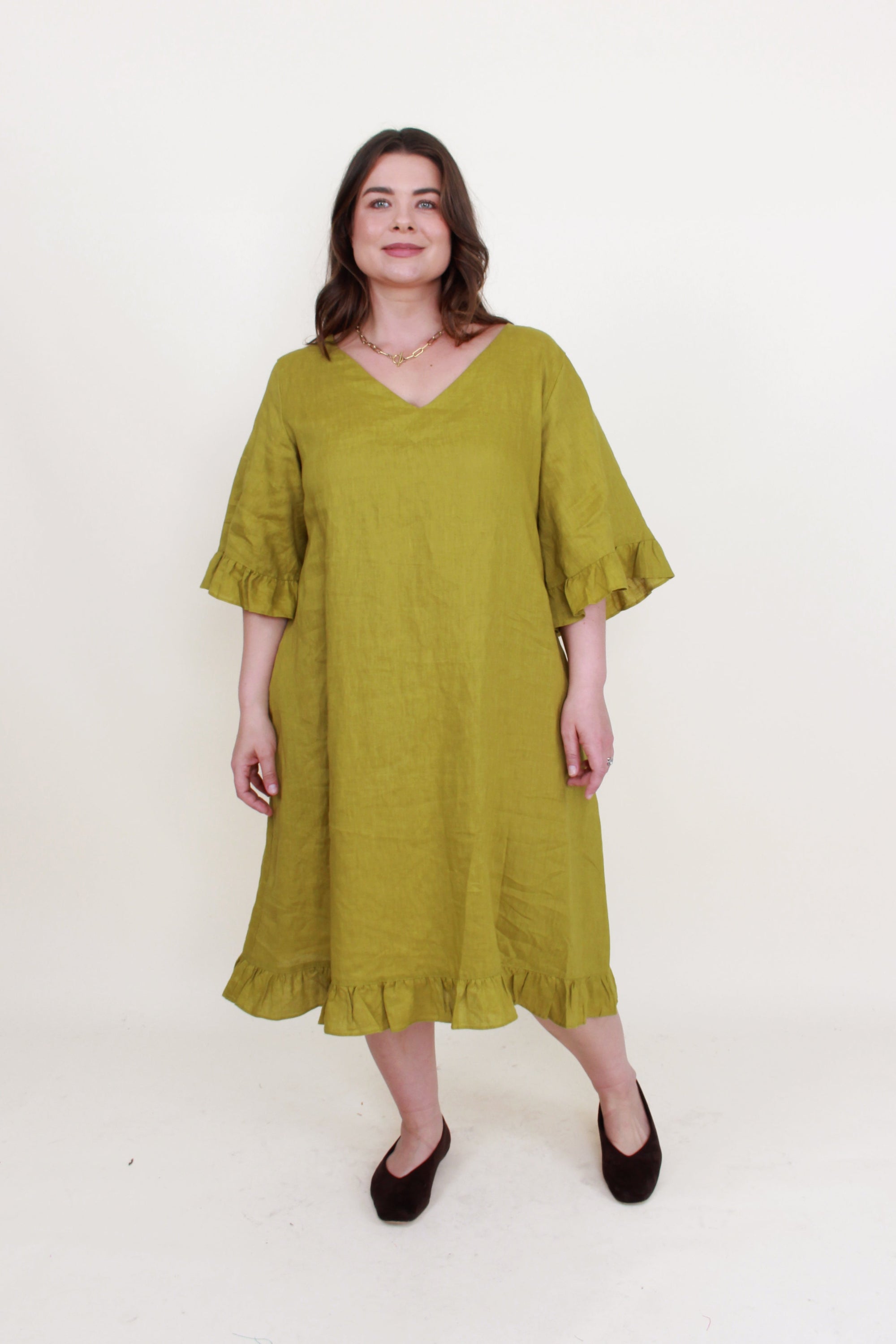 avocado green ruffle hem linen midi dress worn by model 