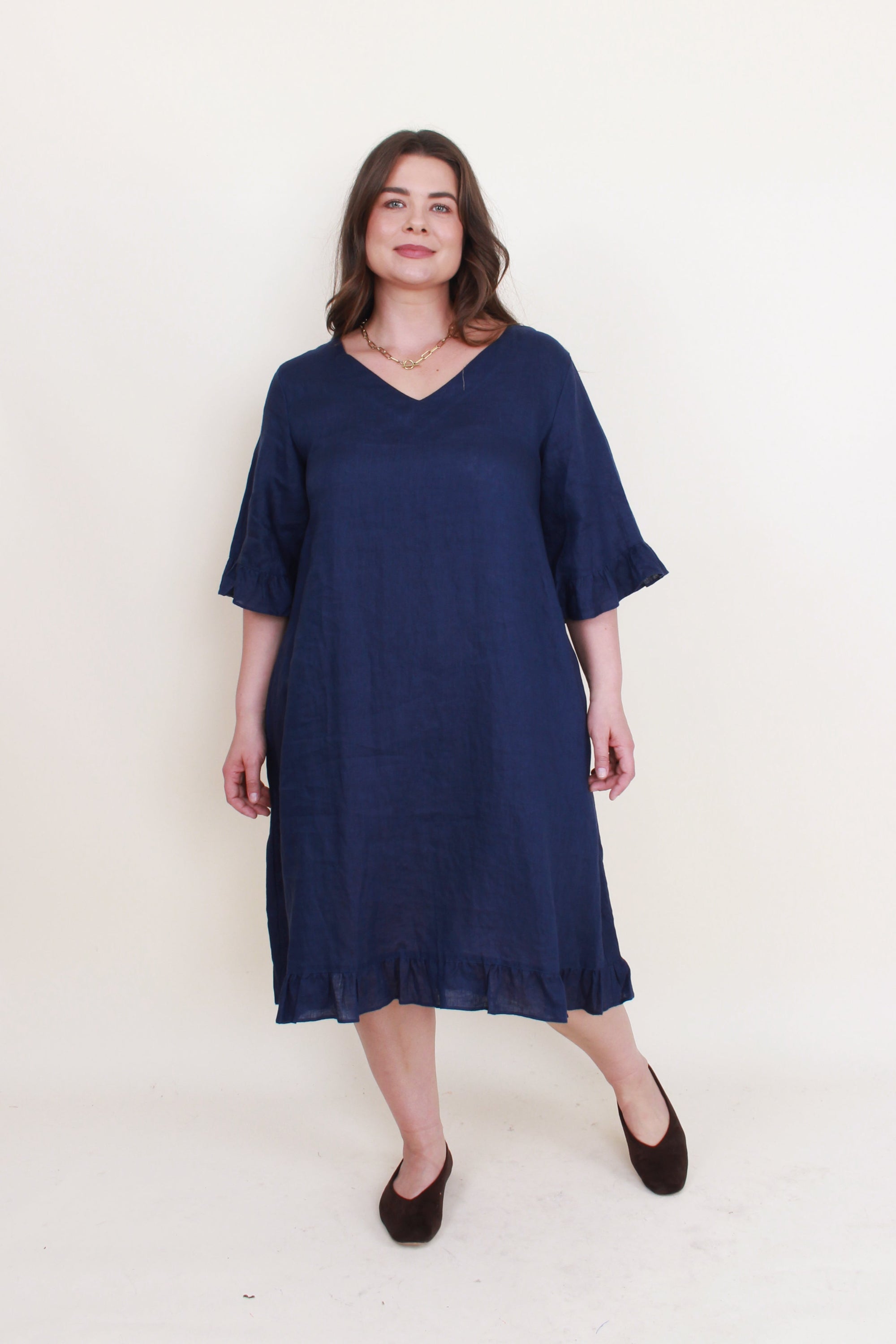 navy ruffle hem linen midi dress worn by model 