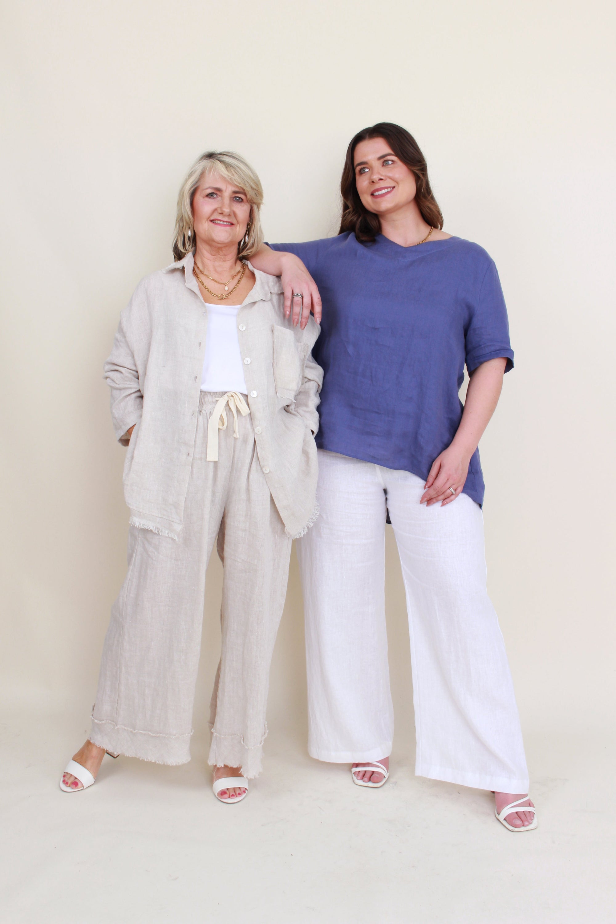 womens button through shirt with fray hems in sand and womens blue linen top worn by second model 