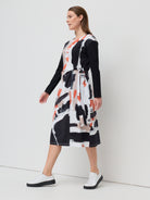 Woman wearing a black and white patterned dress on a white background