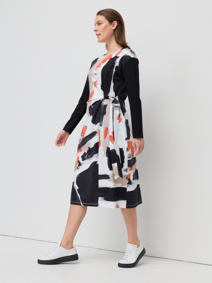 Woman wearing a black and white patterned dress on a white background