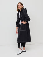 Woman wearing a black coat with a white background
