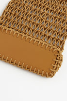 Close-up of a brown woven pouch with a plain background