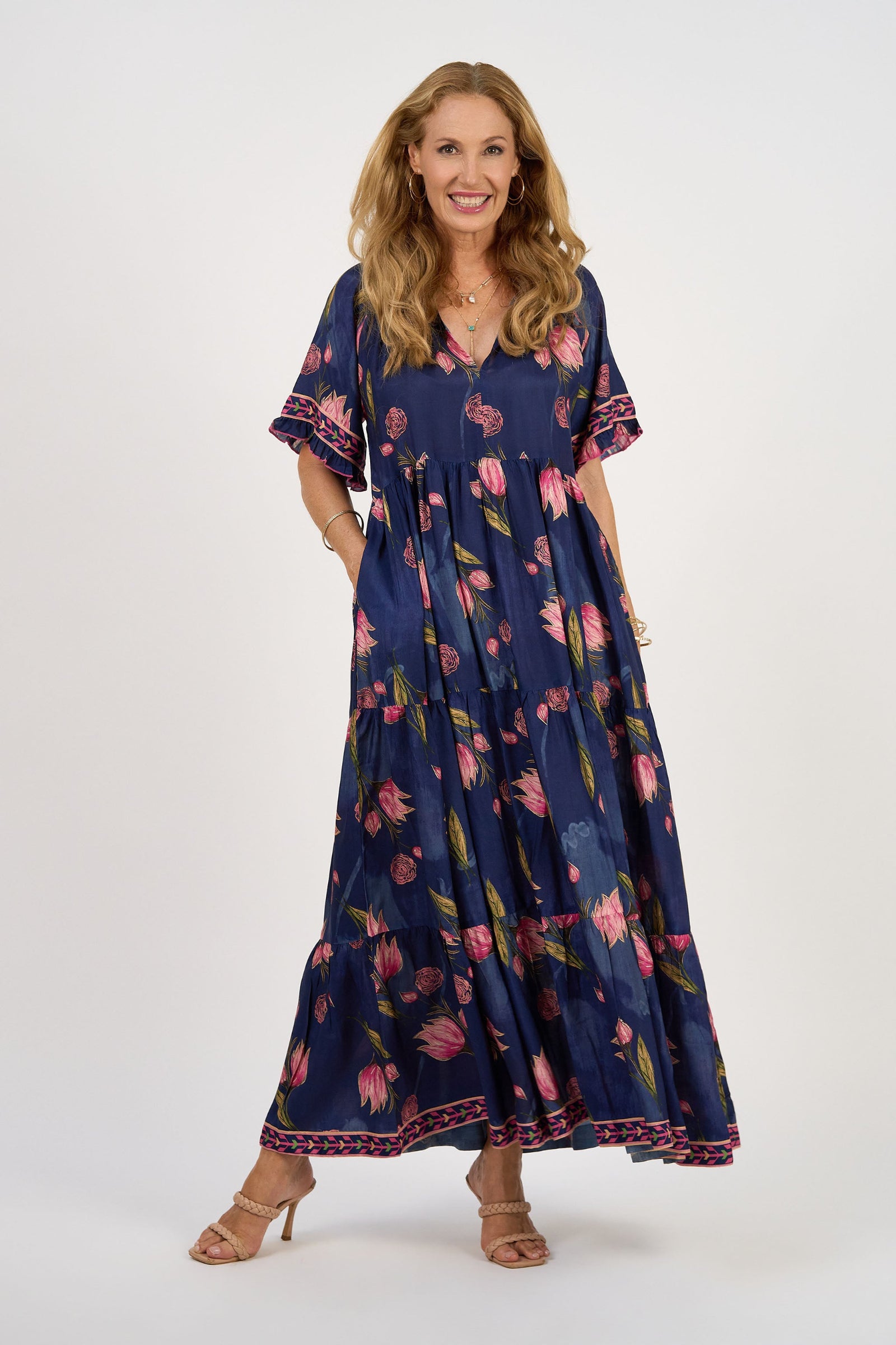 Woman wearing a navy floral dress on a white background