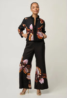 women wearing a black jacket with a floral design on a plain background