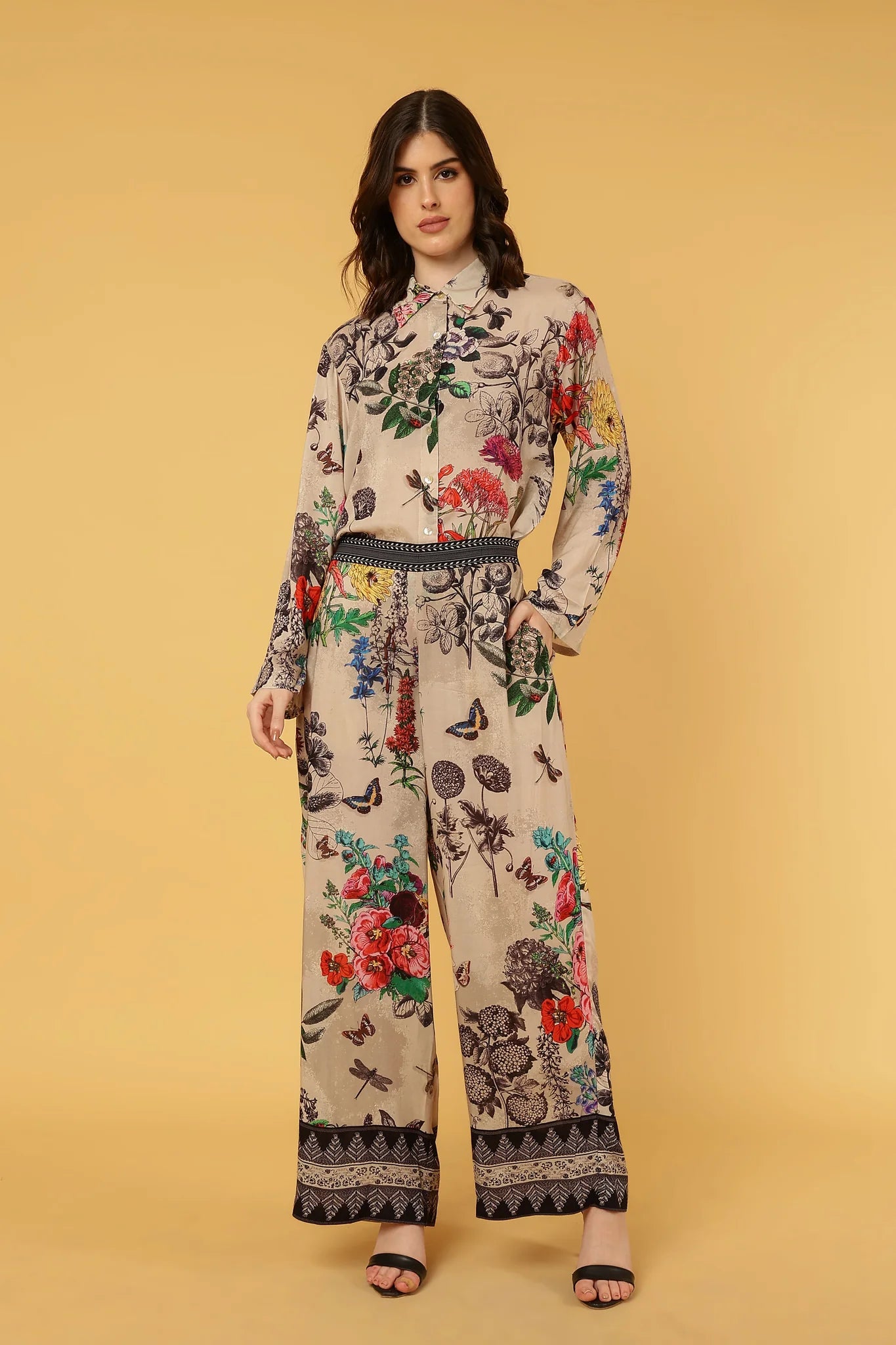 women wearing floral and butterfly pattern pants and shirt on yellow background