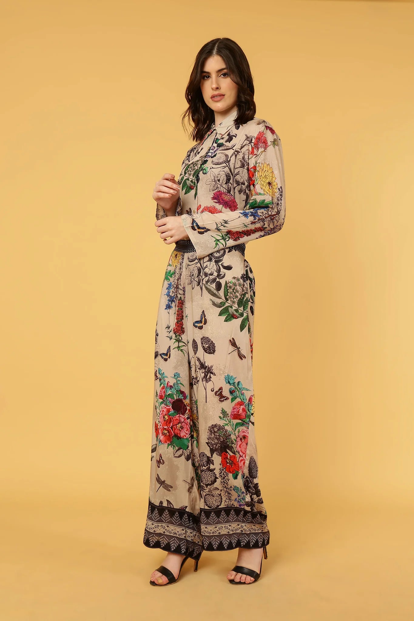 women wearing floral and butterfly pattern pants and shirt on yellow background