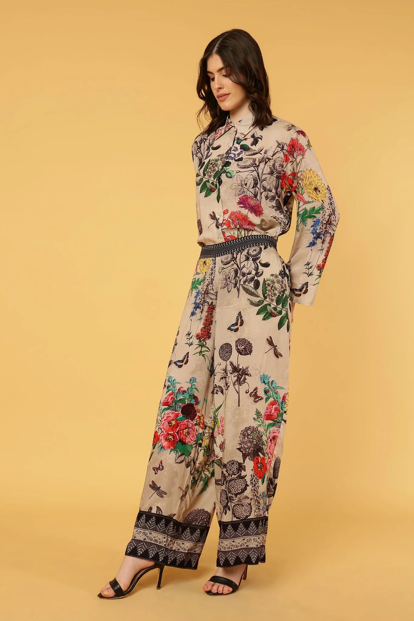 women wearing floral and butterfly pattern pants and shirt on yellow background