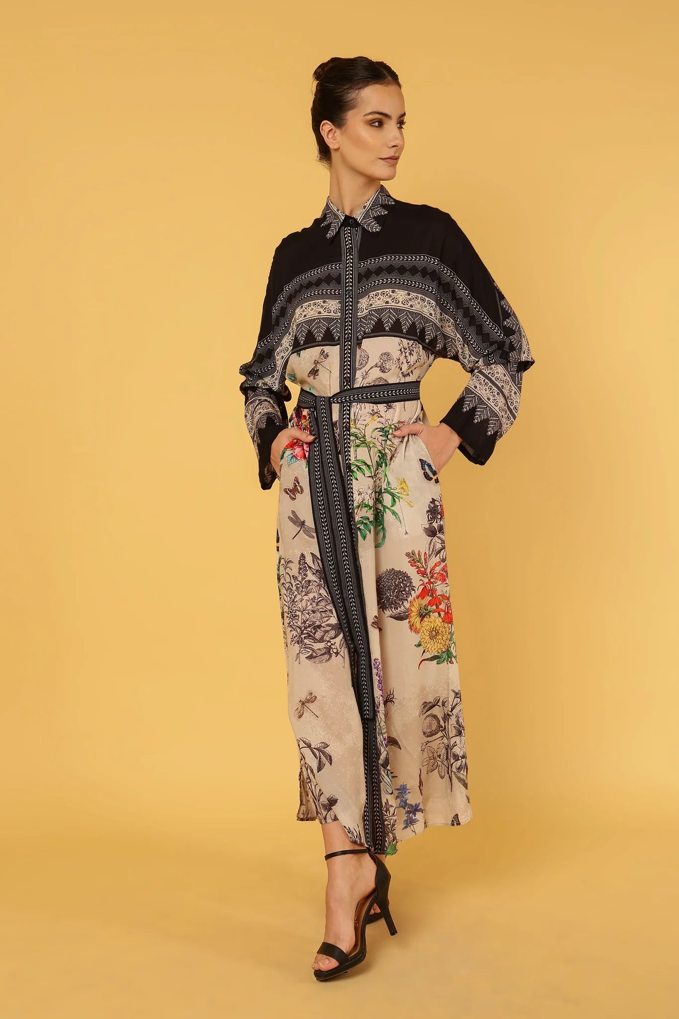 Woman wearing a floral dress with a black pattern on a yellow background