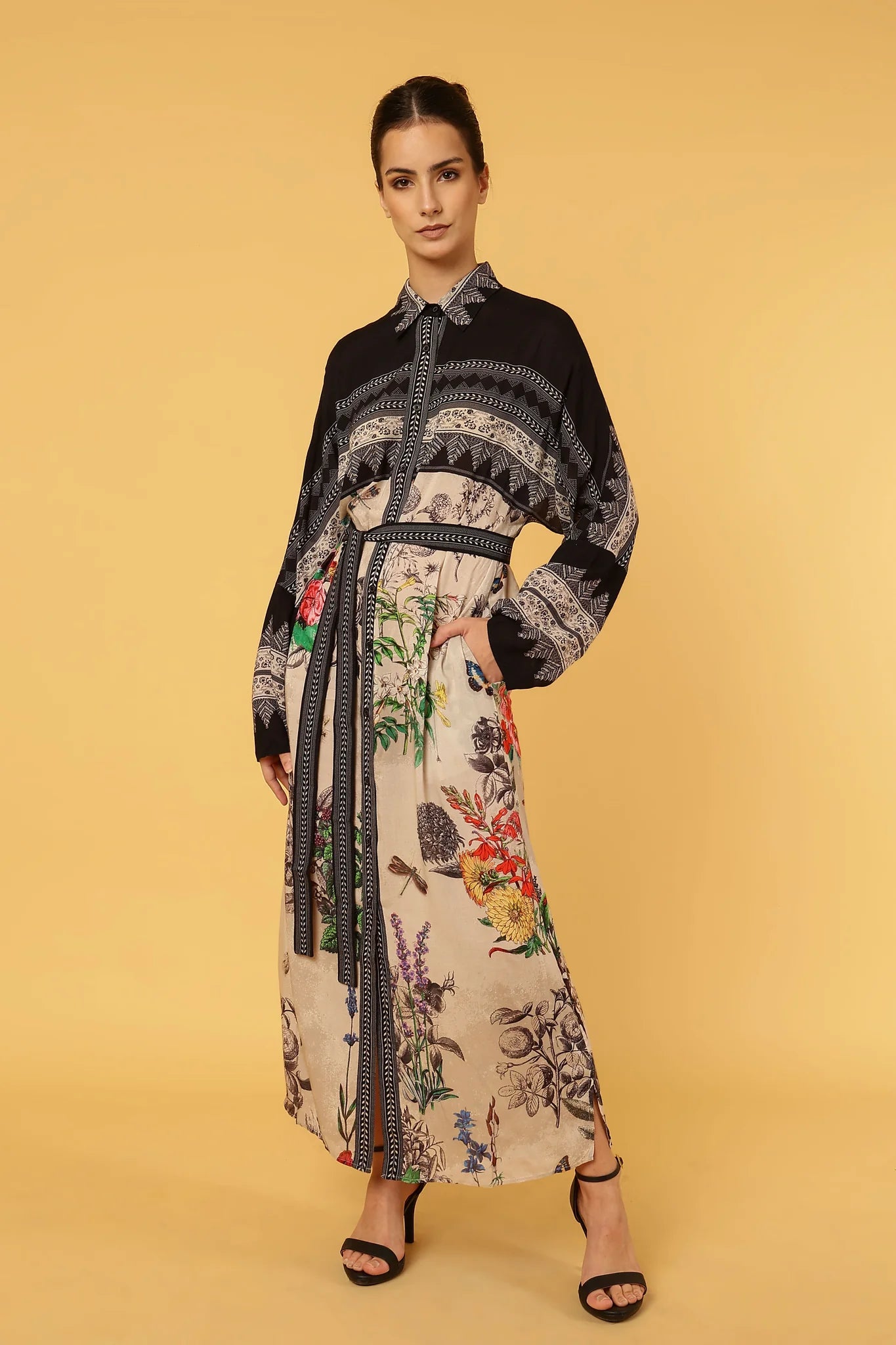 Woman wearing a floral dress with a black pattern on a yellow background