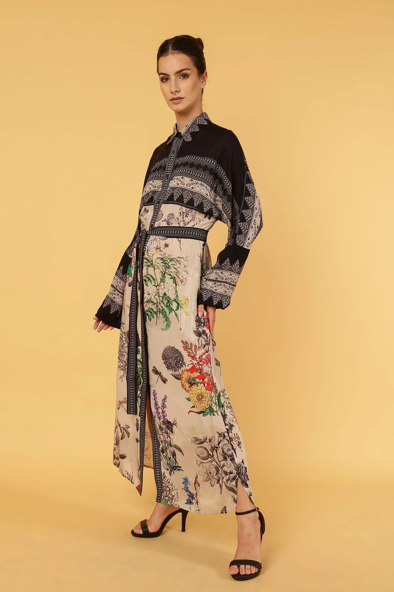 Woman wearing a floral dress with a black pattern on a yellow background