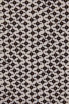 A close-up of a fabric pattern featuring a repeating geometric design of small black circles and dots on a light beige background, with some motifs highlighted in orange.
