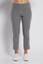 Black and white gingham cropped pants shown on a model from the waist down, paired with white sneakers against a light gray studio background.