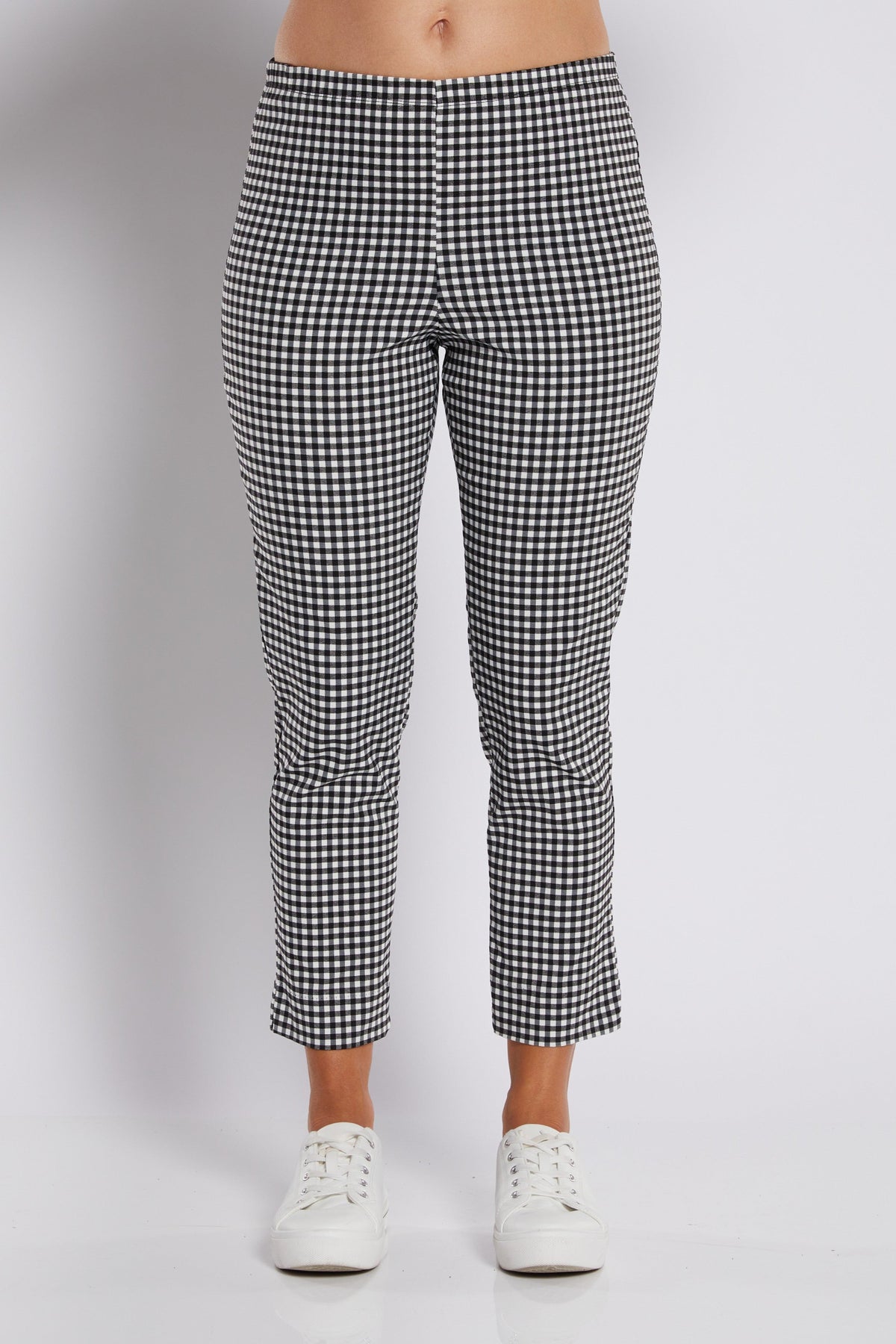 Black and white gingham cropped pants shown on a model from the waist down, paired with white sneakers against a light gray studio background.