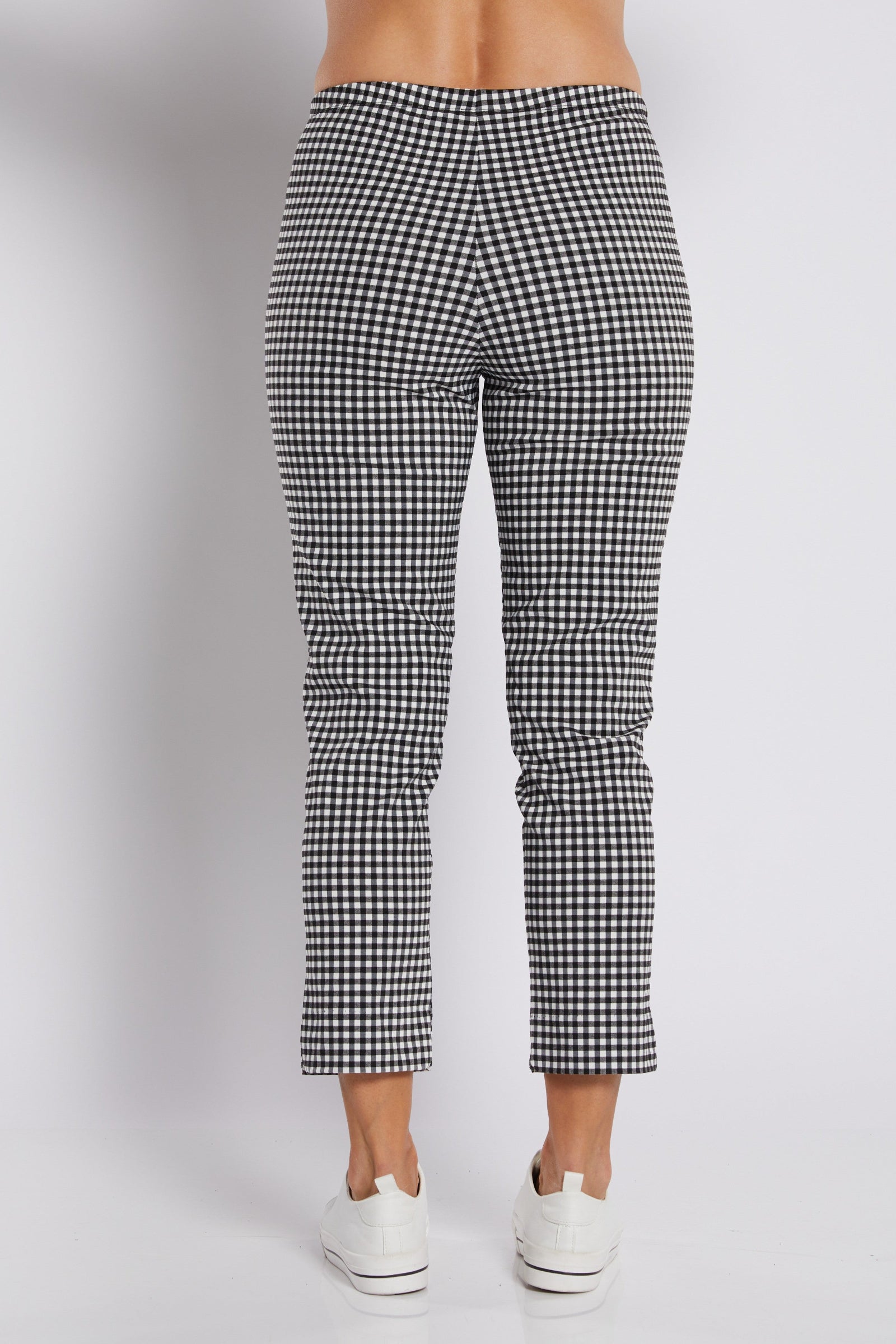 Black and white gingham cropped pants shown from the back on a model, paired with white sneakers against a light gray studio background.