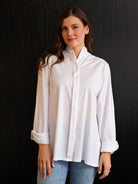 Woman wearing a white blouse against a black background