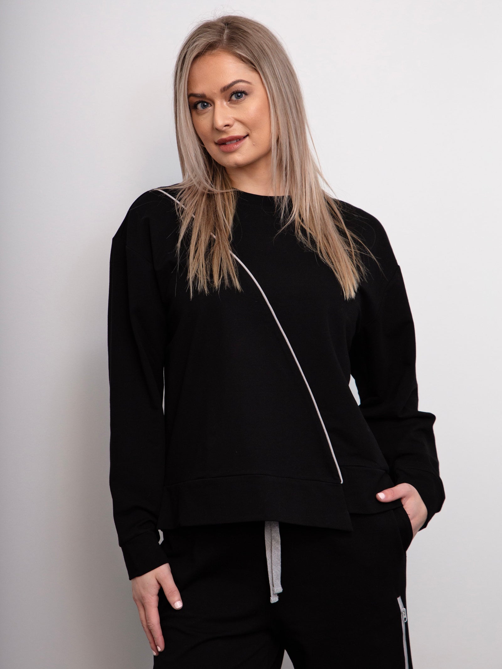 Woman wearing a black outfit on a plain background