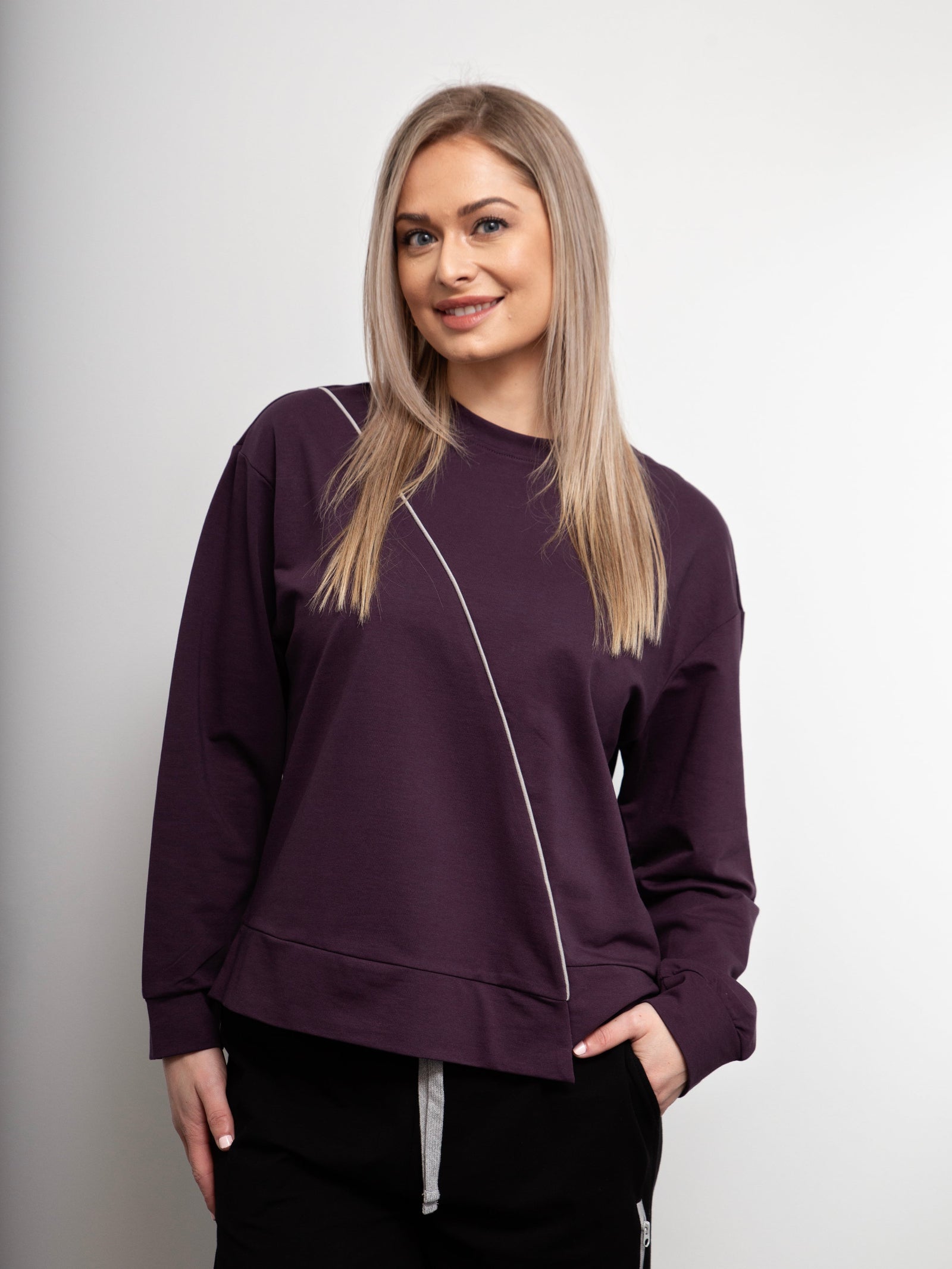 Woman wearing a purple sweatshirt against a plain background