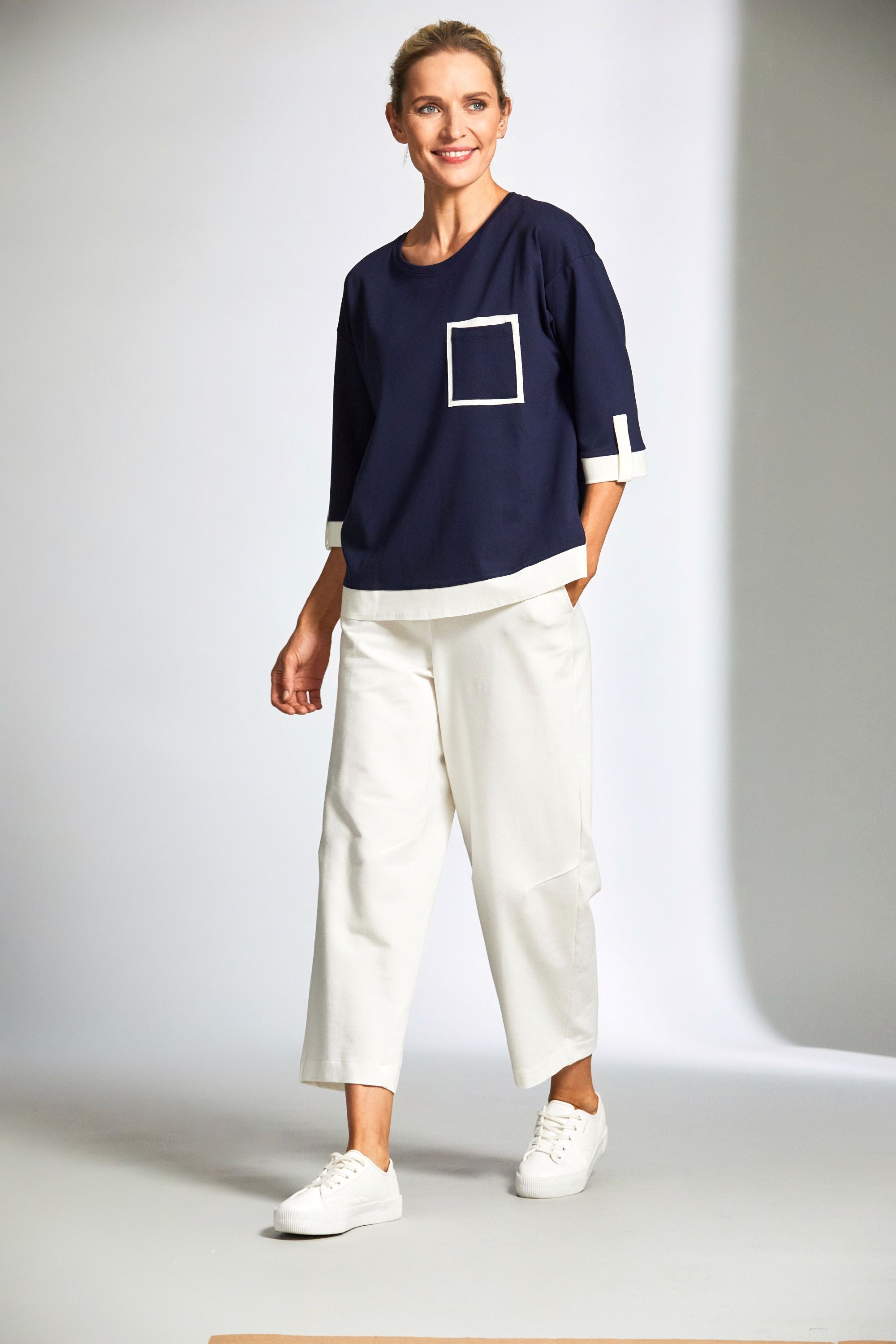 womens top in navy with ecru contrast details and ecru pants worn by model