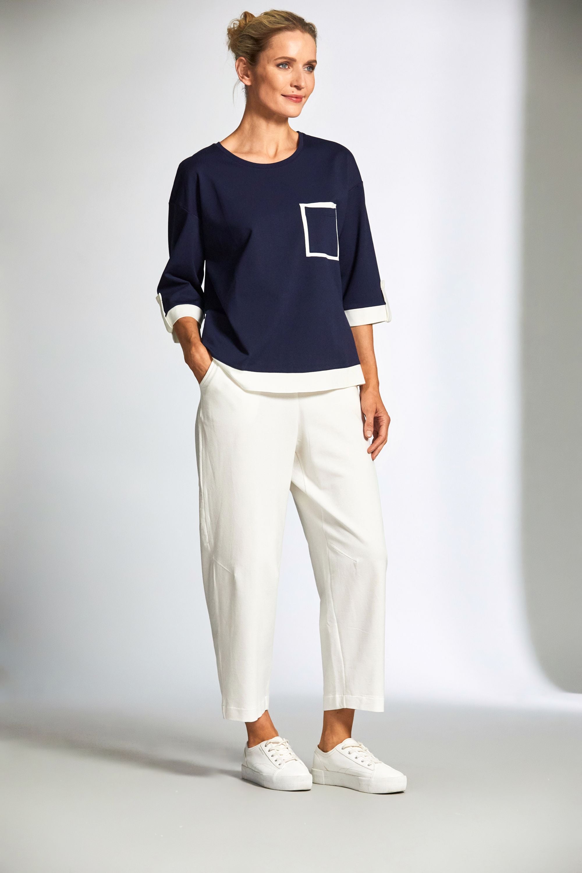 womens top in navy with ecru contrast details and ecru pants worn by model