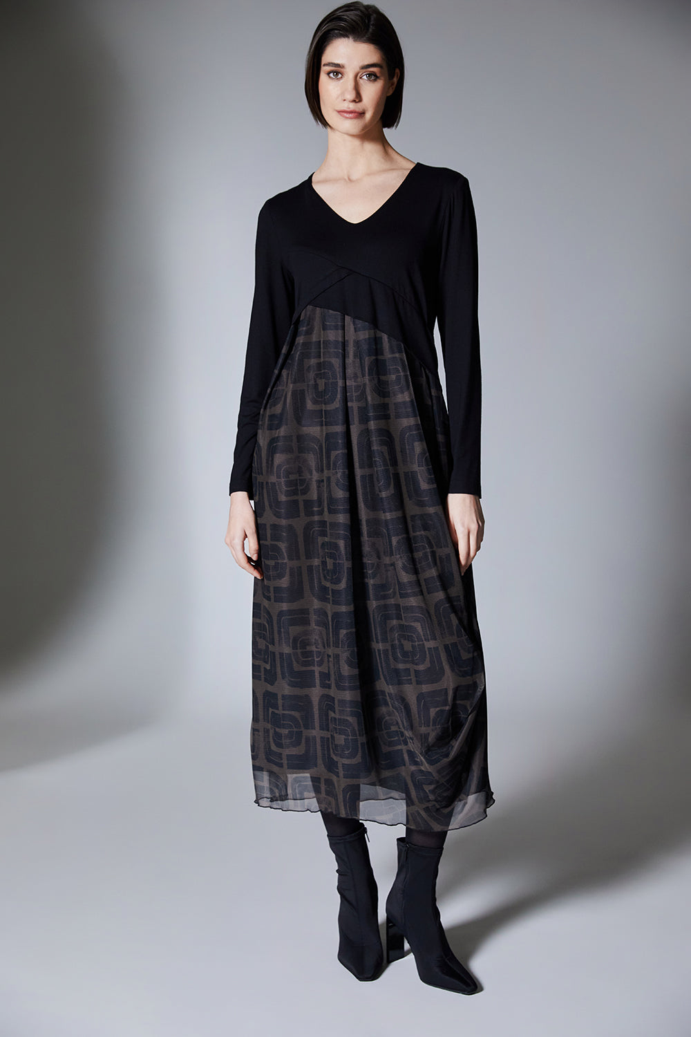 Woman wearing a black and brown patterned dress on a gray background