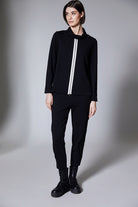 Person wearing a black outfit with a white stripe on a gray background