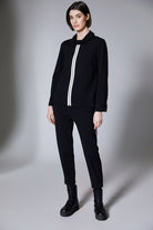 Person wearing a black outfit with a white stripe on a gray background