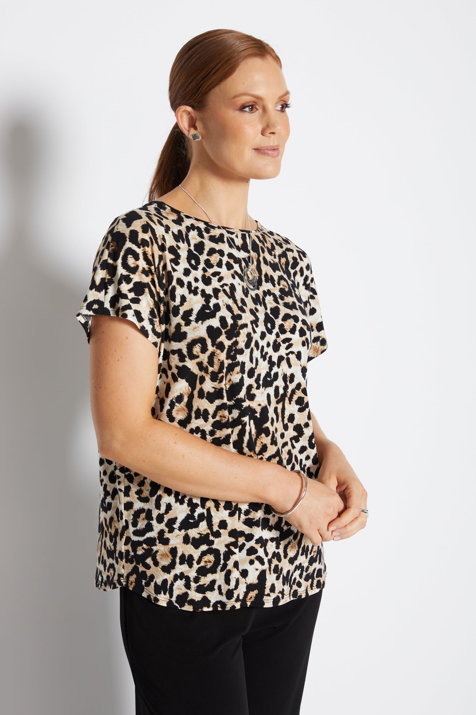 Woman wearing a leopard print top against a plain background