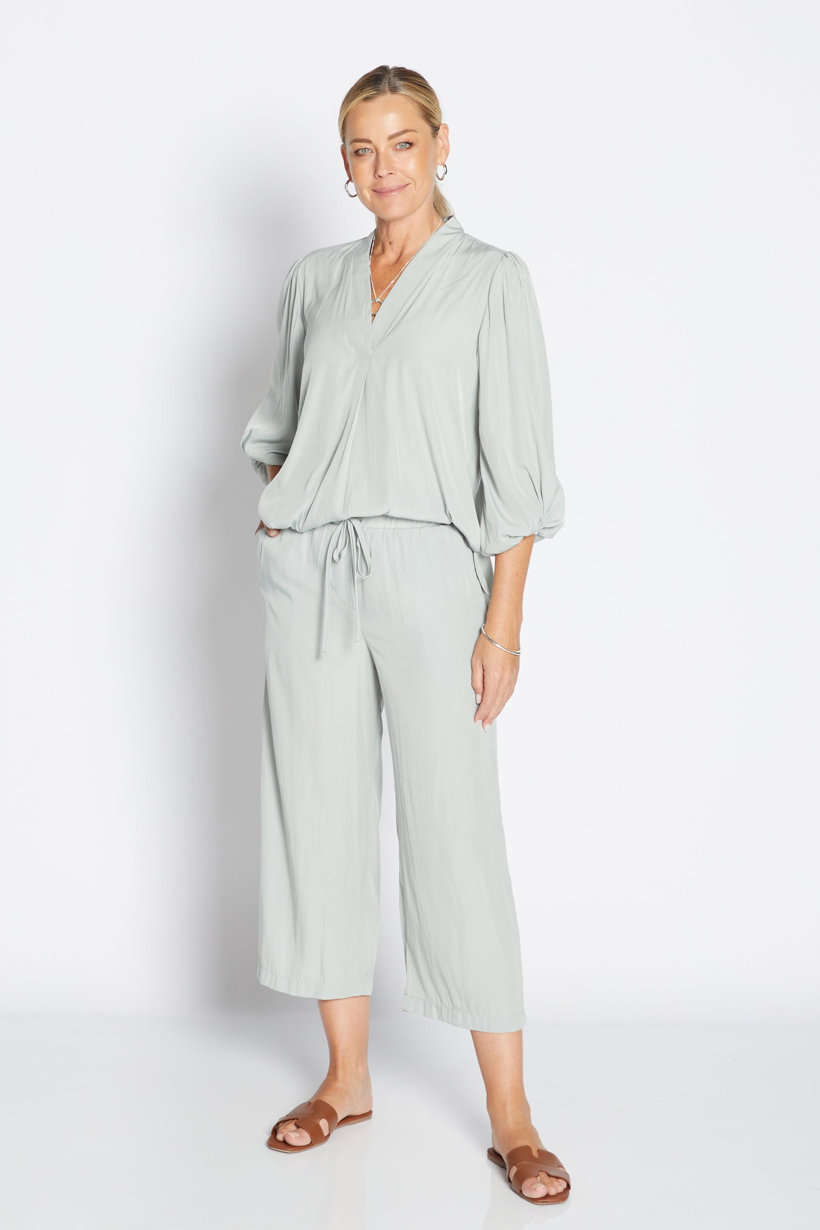 Woman wearing a light green outfit on a white background