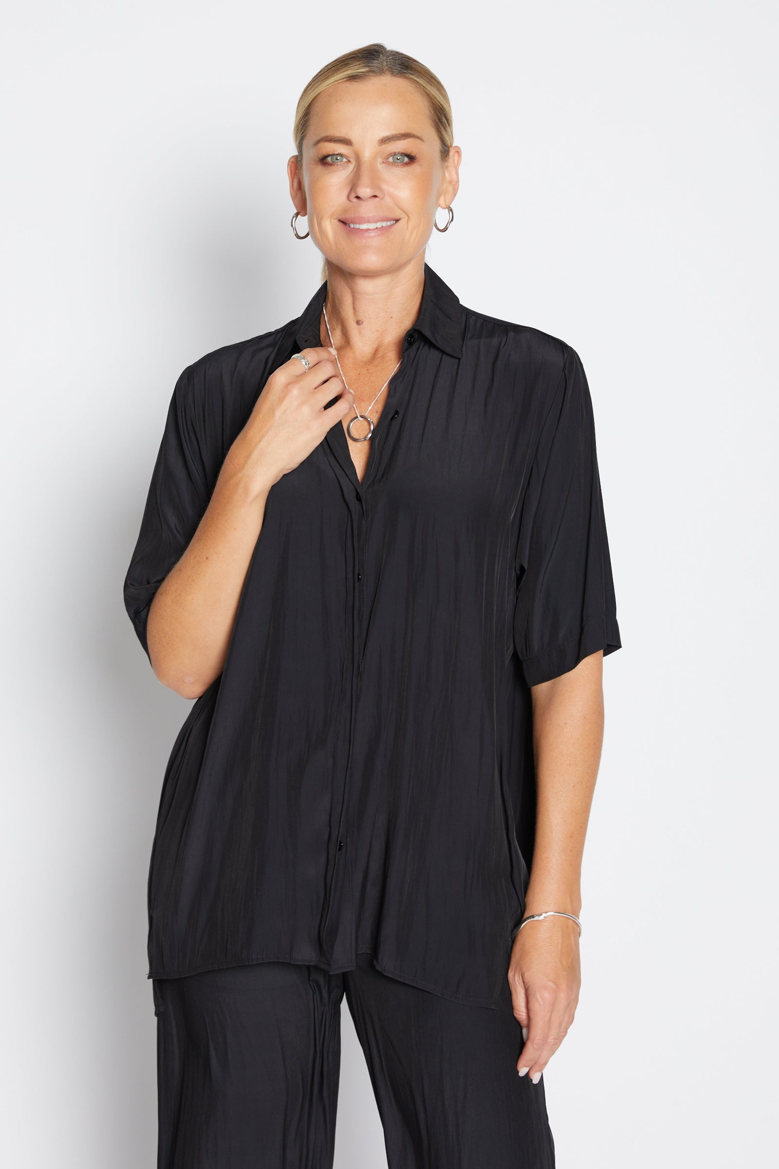 Woman wearing a black shirt and pants on a white background