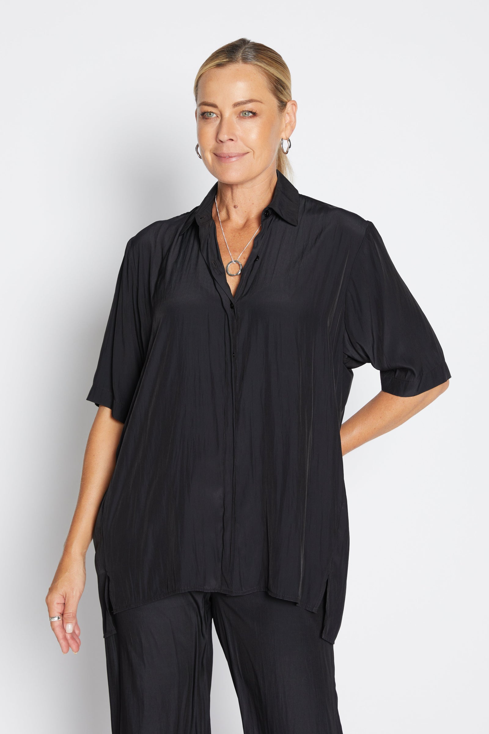 Woman wearing a black shirt and pants on a white background