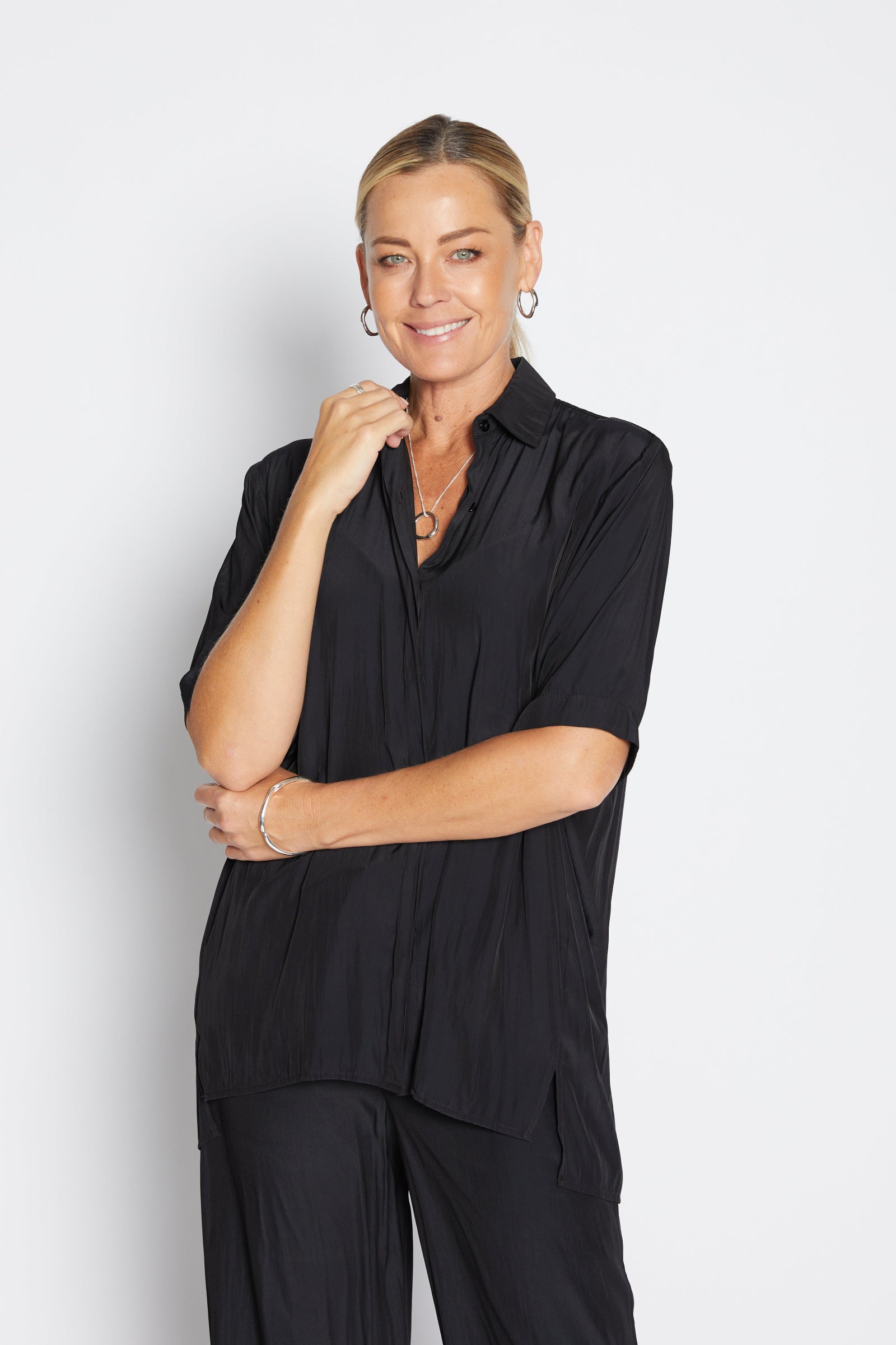 Woman wearing a black outfit against a white background