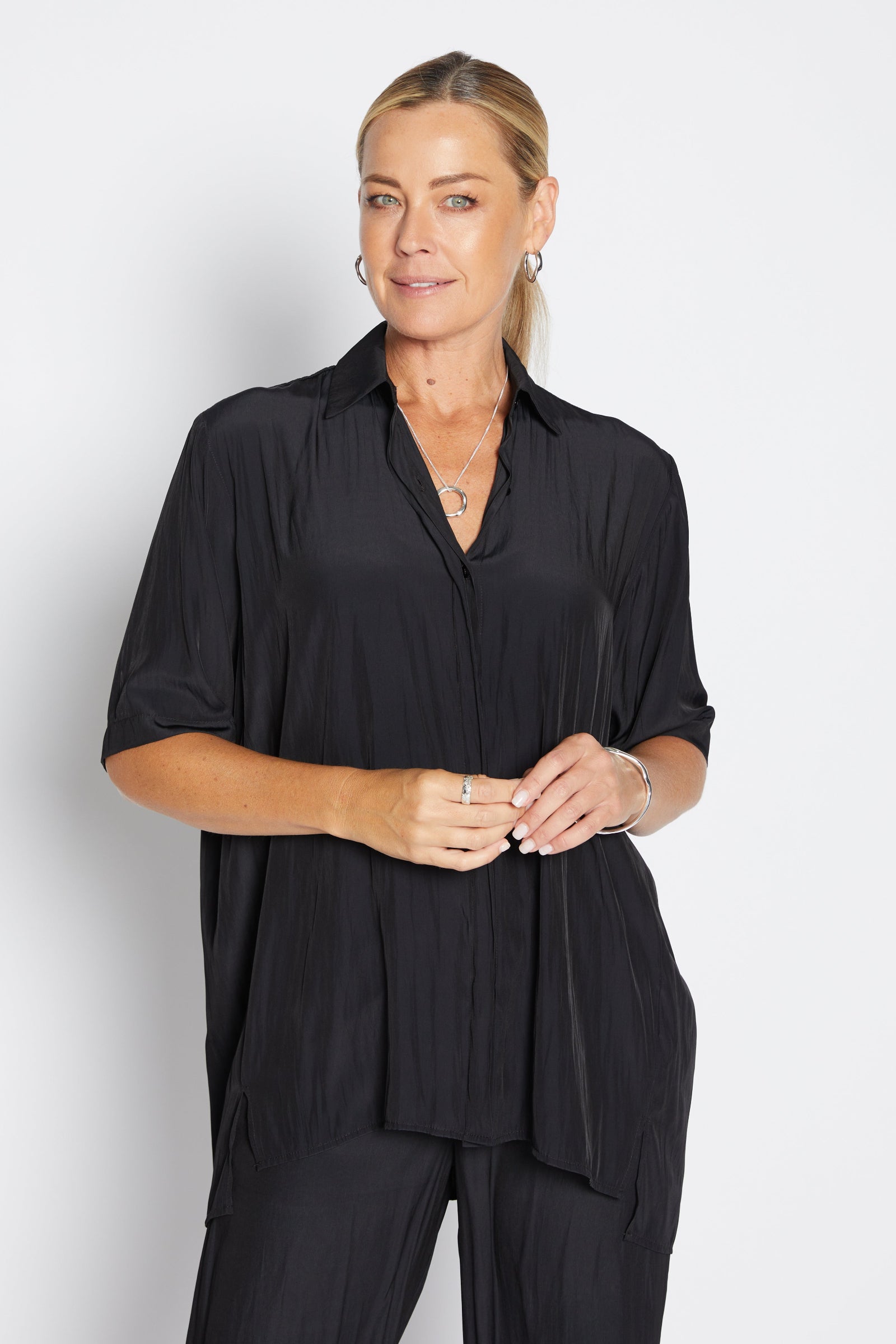 Woman wearing a black outfit against a white background